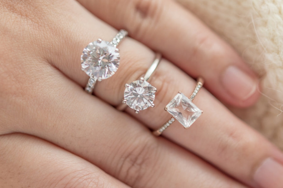 Woman Wearing Three Engagement Rings Made of Lab Grown Diamonds and Simulants